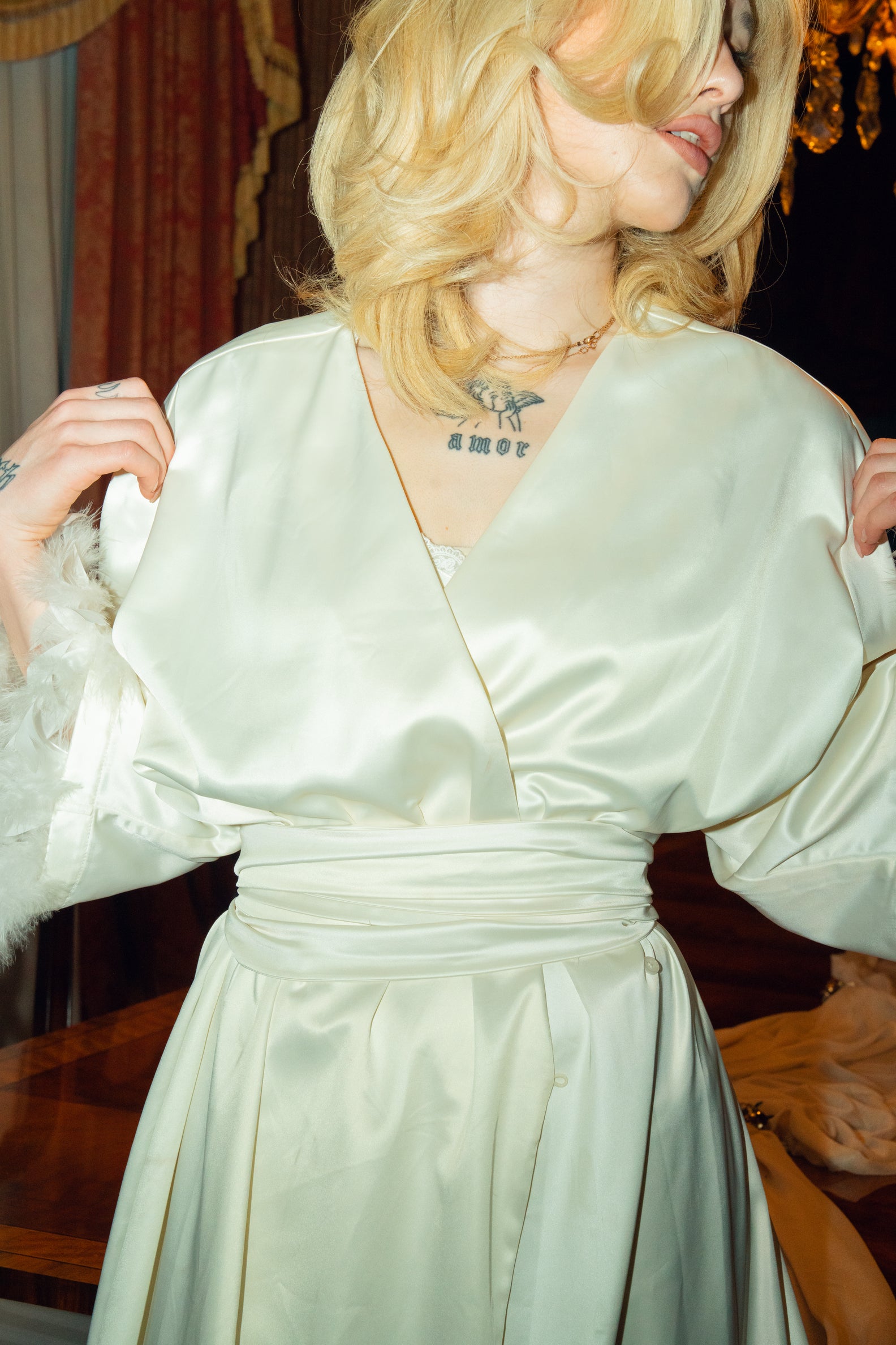 Person wearing a light green satin dress with a blurred background