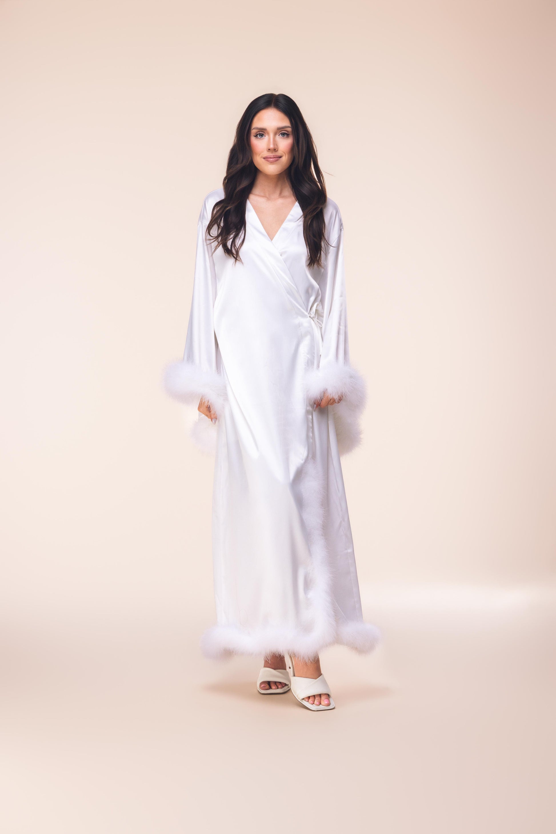 Woman wearing a white dress against a beige background