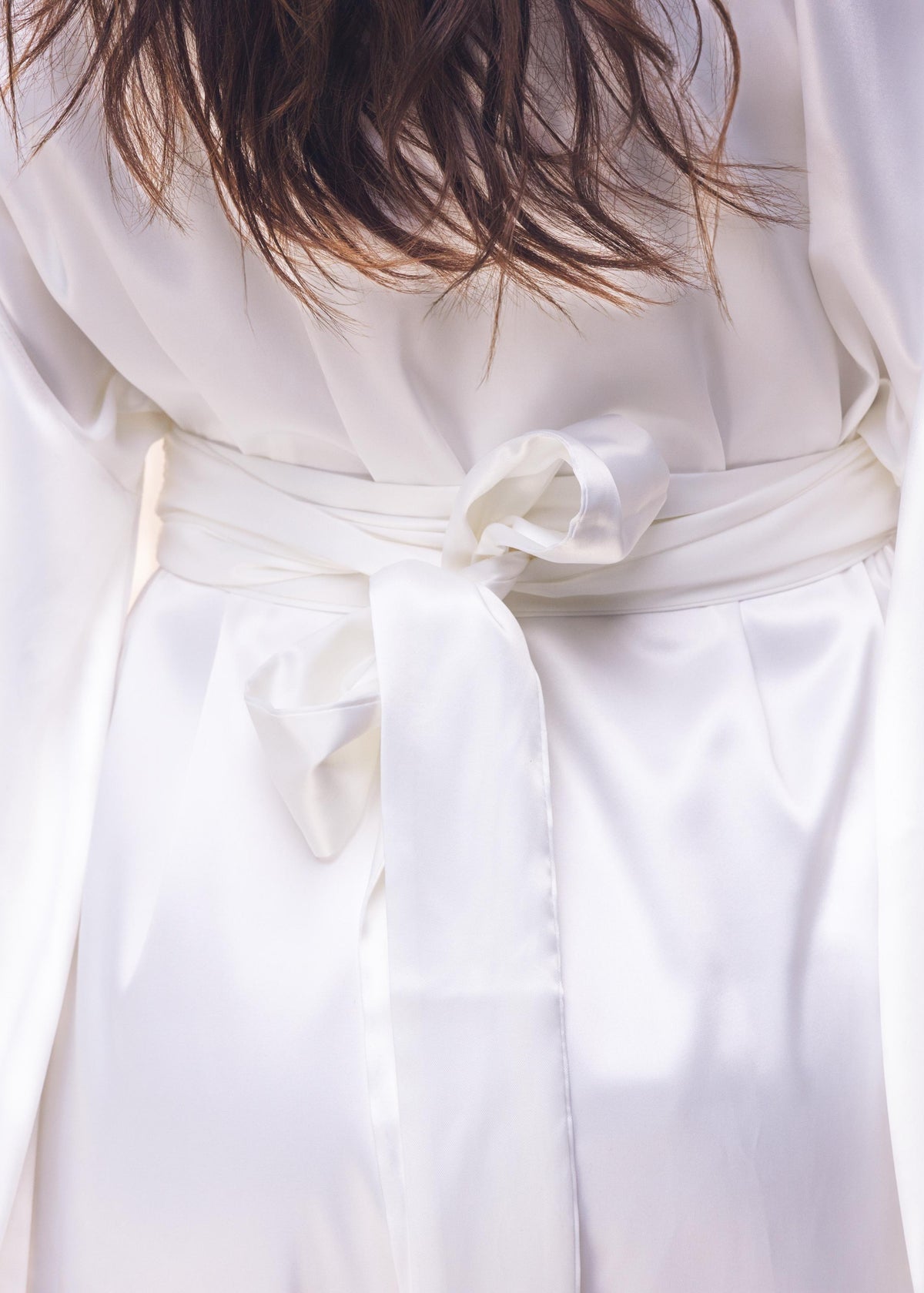 White dress with a bow detail on a light background