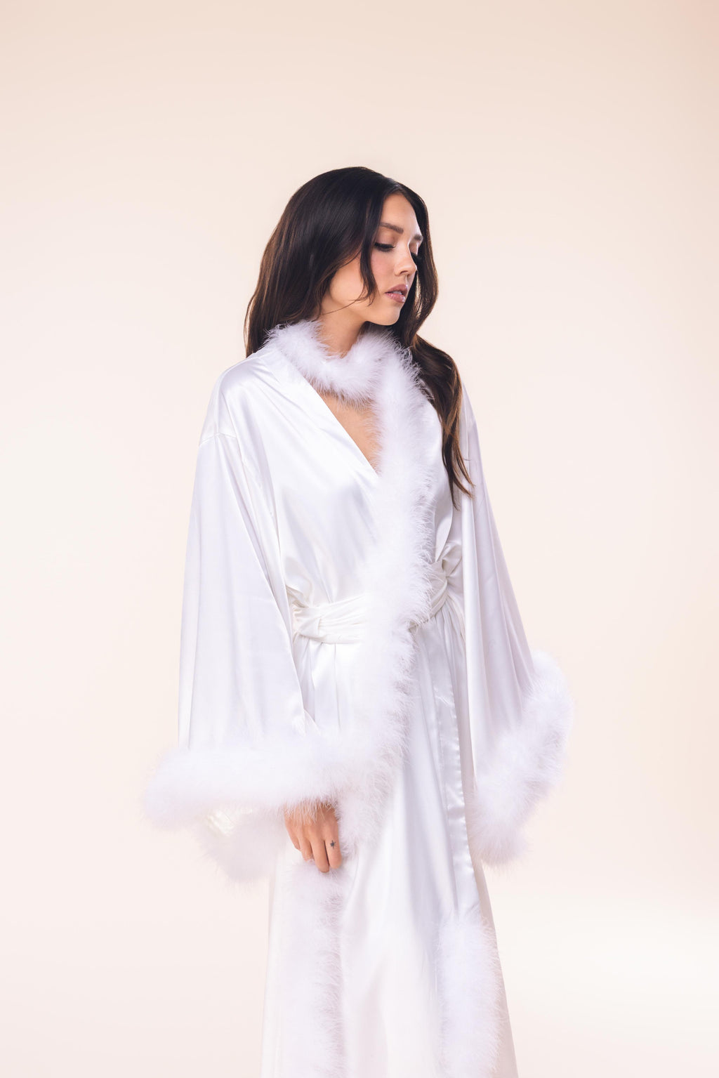 Woman wearing a white robe against a plain background