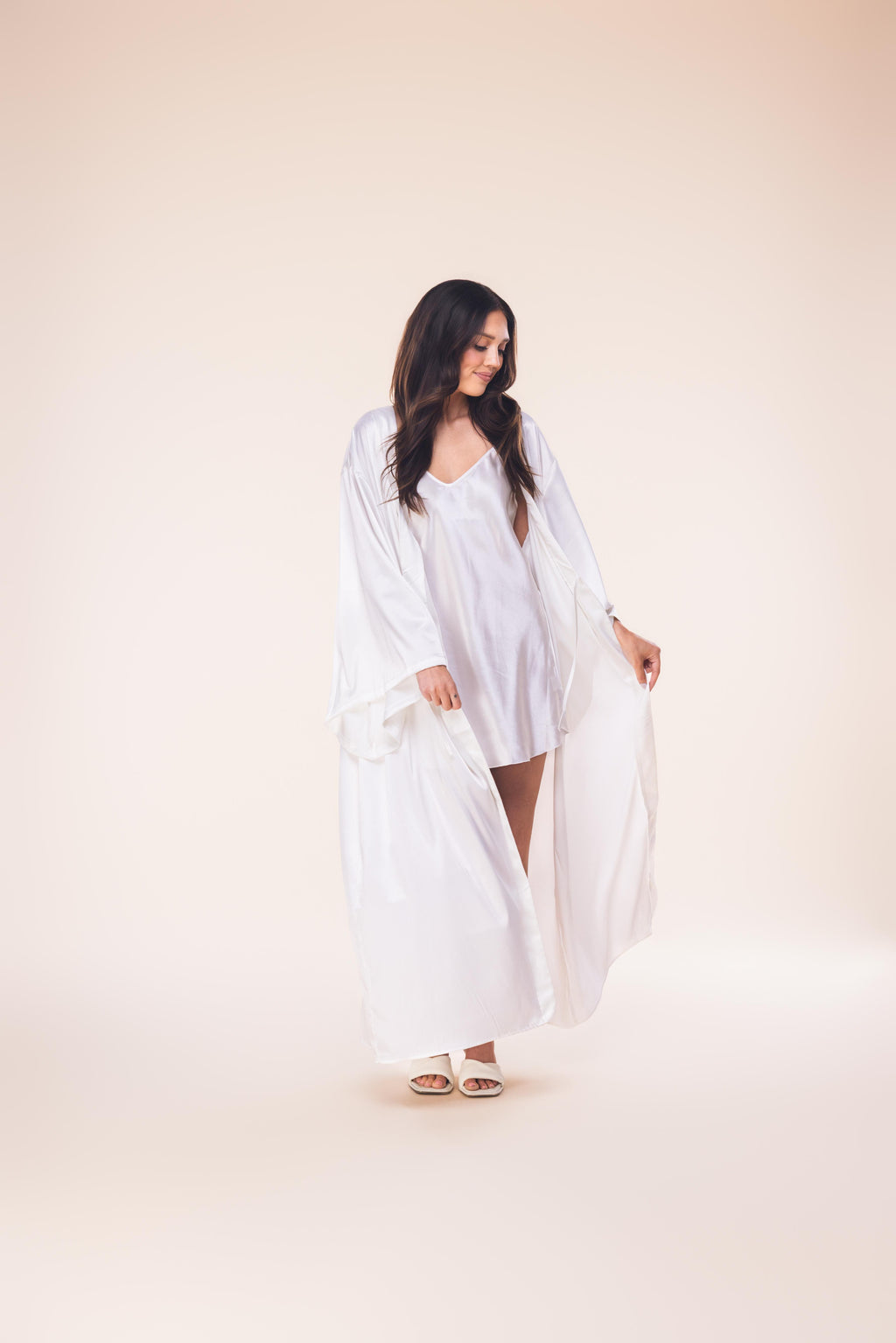 Woman wearing a white dress against a plain background