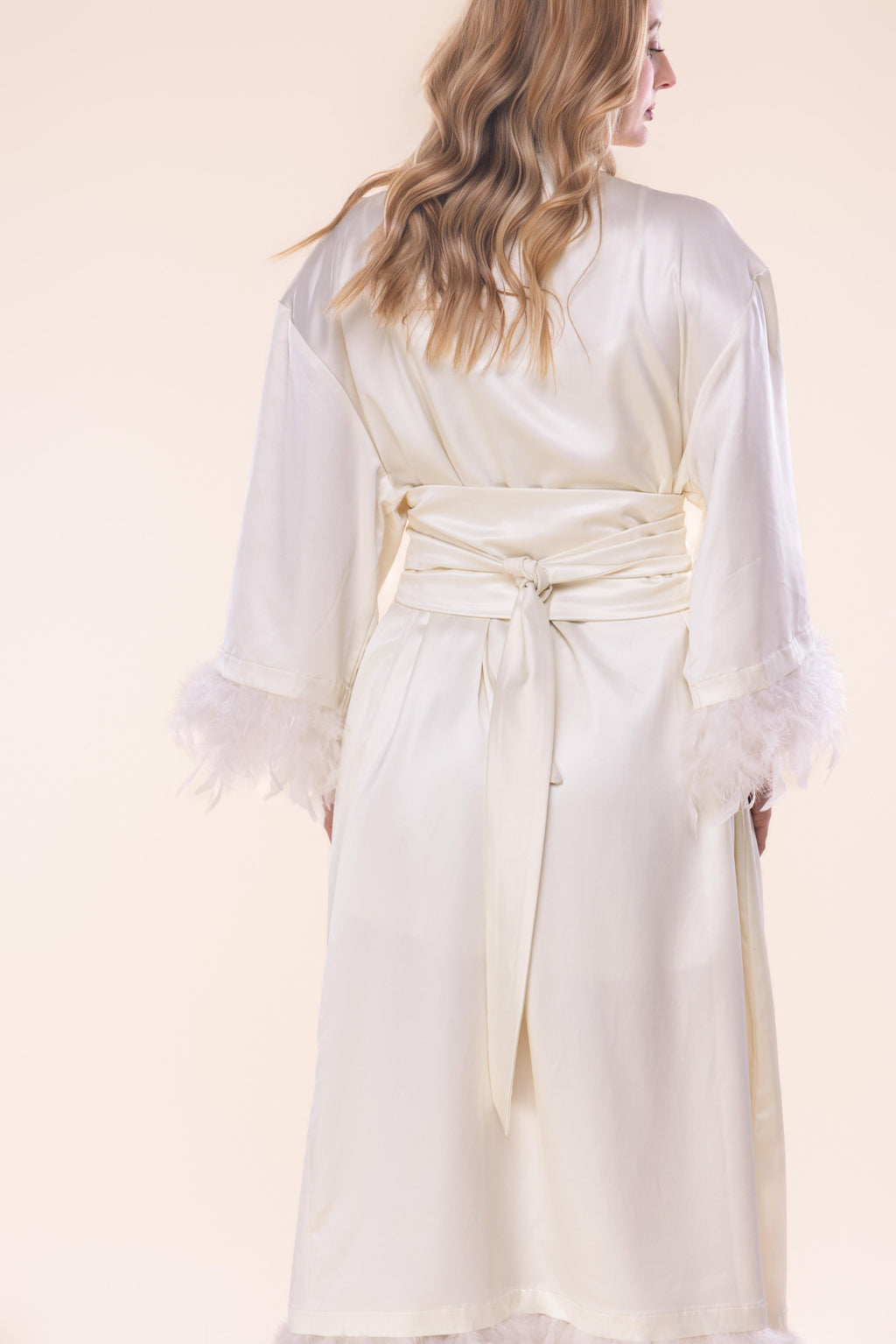 White robe worn by a person on a light pink background