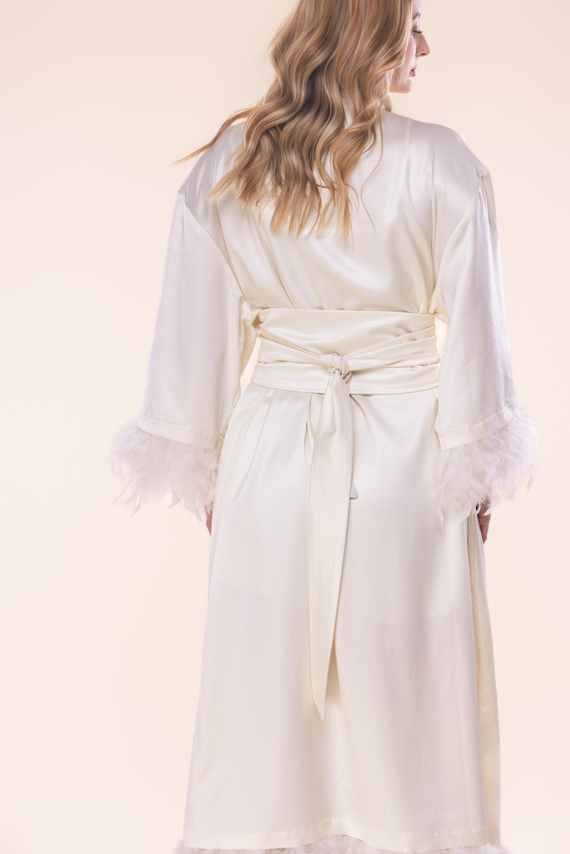 White robe worn by a person on a light pink background