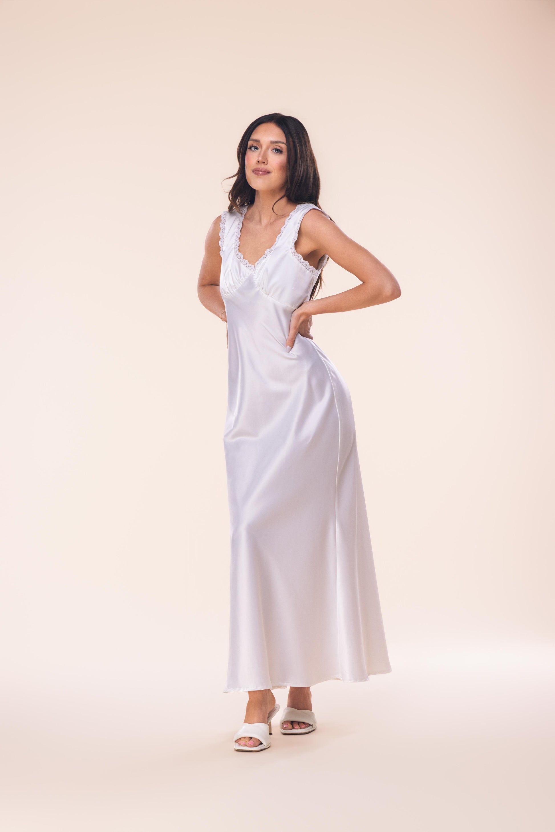 Woman wearing a white dress against a beige background